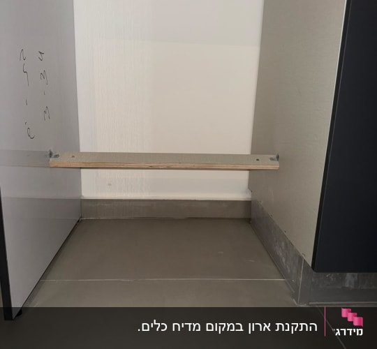 תמונה של ארון מטבח ריק עם מדף עץ